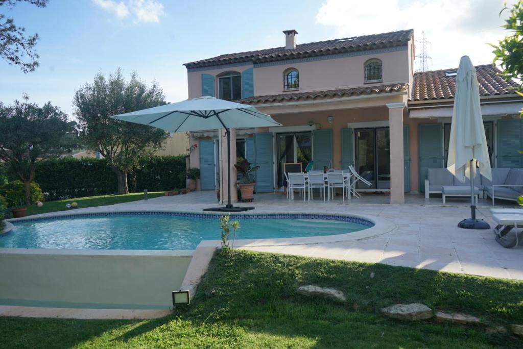 une maison avec une piscine et un parasol dans l'établissement Villa avec piscine - Mougins - domaine privé, à Mougins