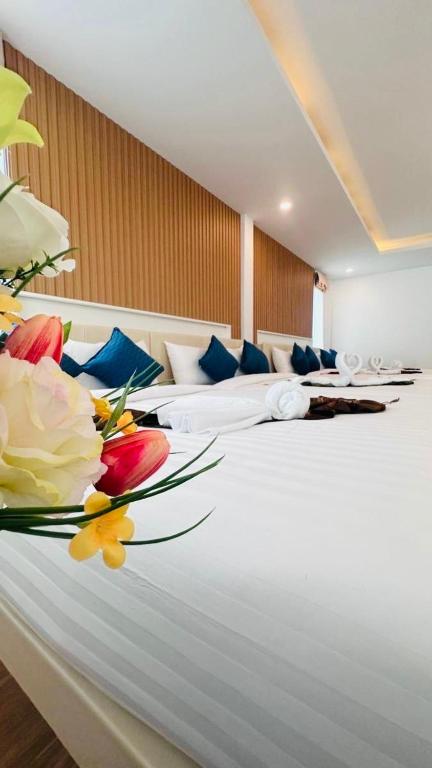 a hotel room with two beds with flowers on the bed at Colour Beach Resort in Ban Ro