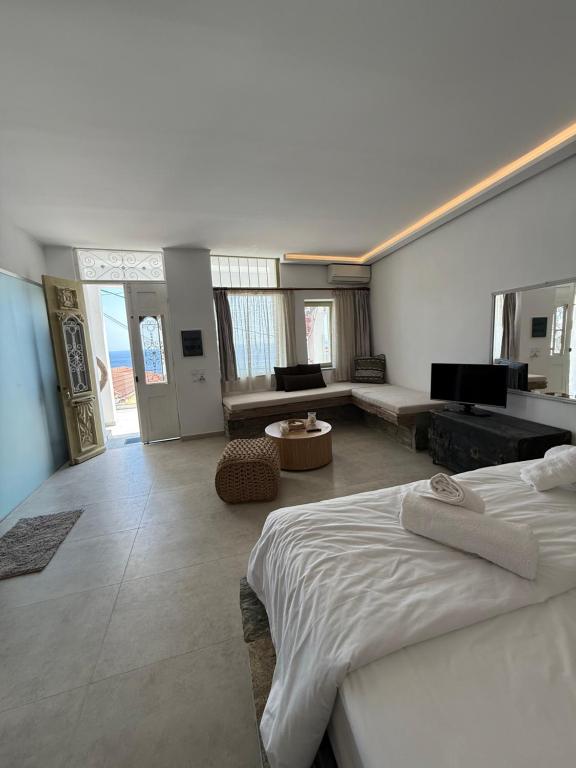 a bedroom with a bed and a living room at Michalelis cave & loft in Plomarion