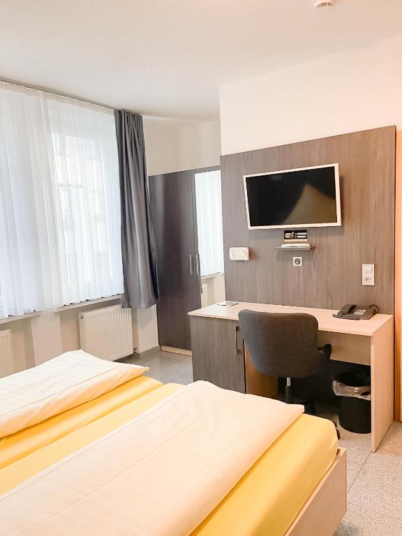 a hotel room with two beds and a desk with a computer at Parkhotel Friedrichstrasse in Gießen