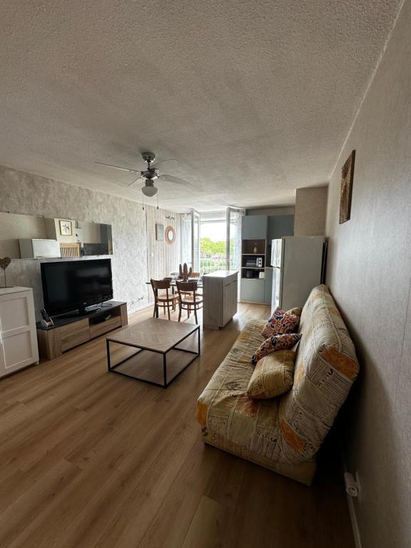 un salon avec un canapé et une table dans l'établissement Appartement Cap d'Agde Le Génois T2 de 36m2 avec parking privatif et accès internet, au Cap d'Agde