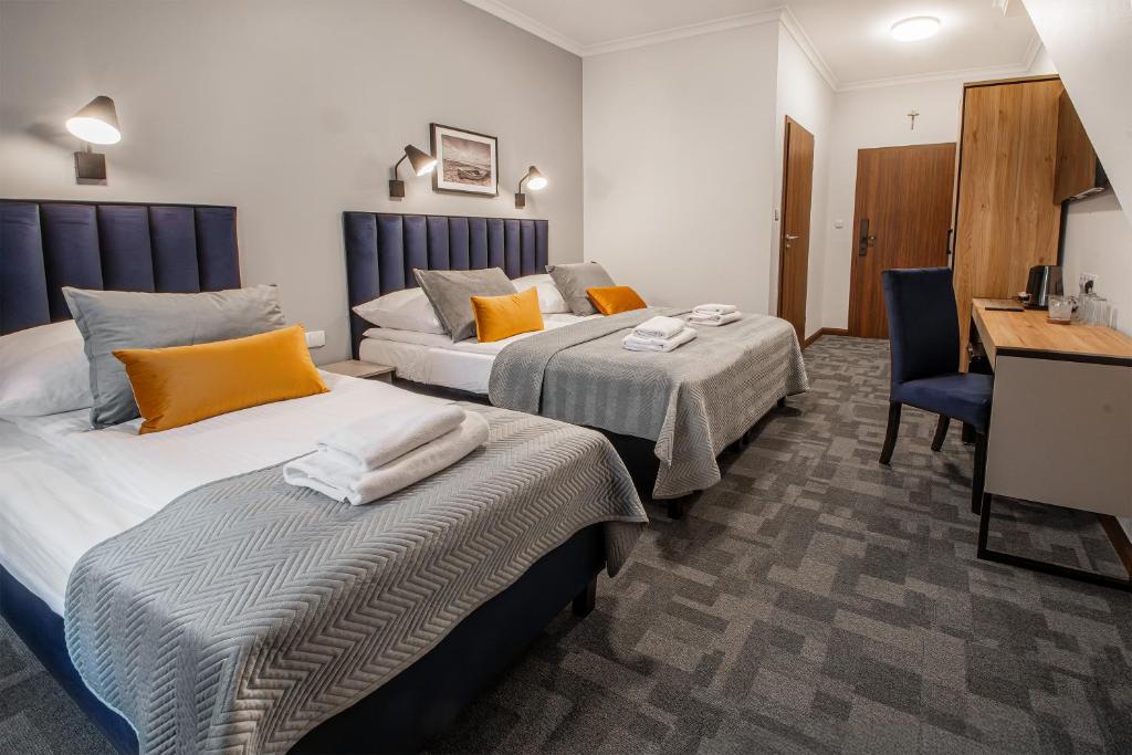 a hotel room with two beds and a desk at Soul Rooms Old Town Gdansk in Gdańsk