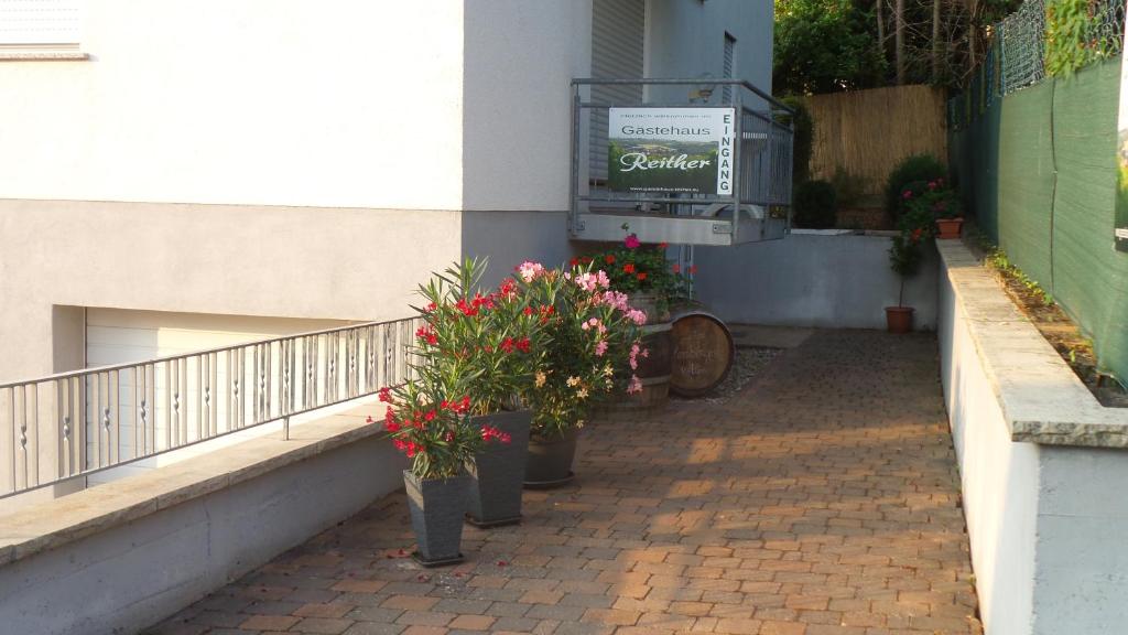 a balcony with potted plants and a sign on a building at Gästehaus Reither in Schweigen-Rechtenbach