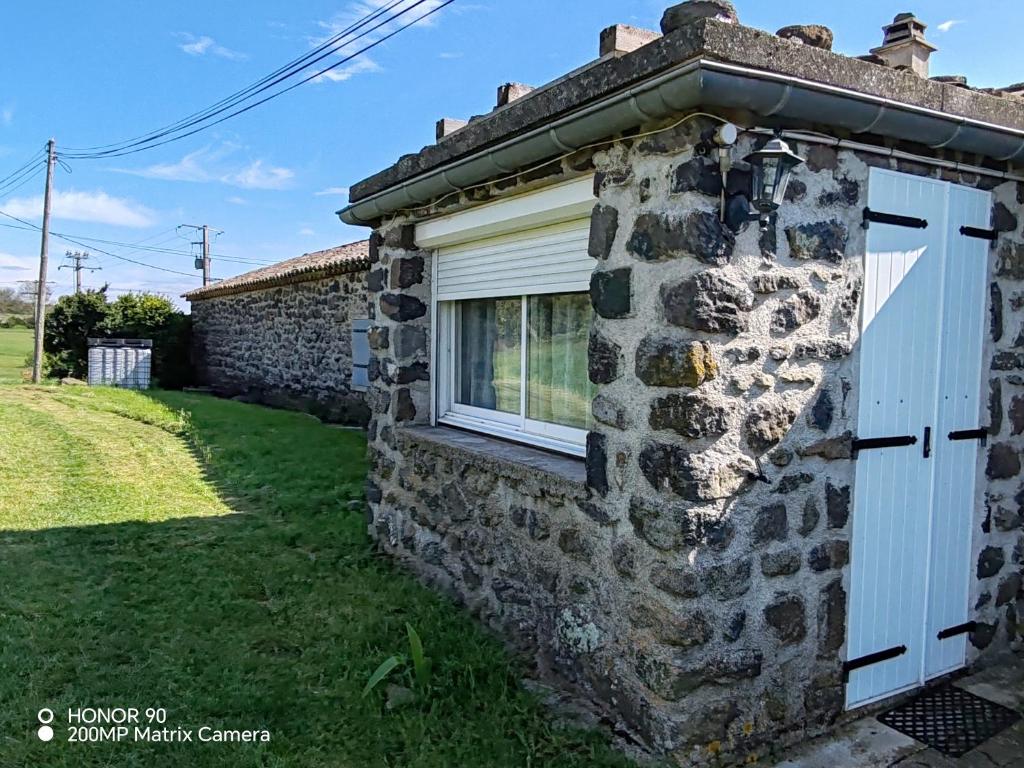 Ce cottage en pierre dispose d'une fenêtre et d'une porte. dans l'établissement Faites une pause, à Saint-Gineis-en-Coiron