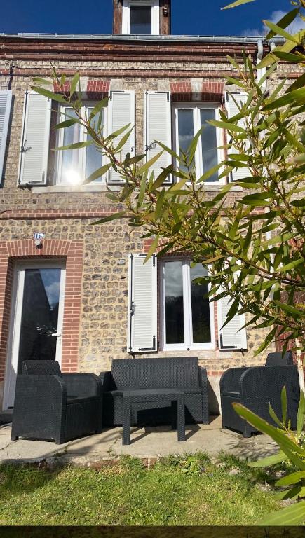 deux canapés noirs et une table devant un bâtiment dans l'établissement House Fisherman, à Yport