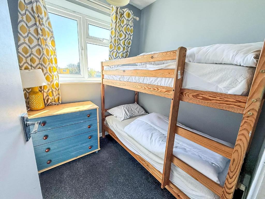 a bunk bed room with two bunk beds next to a window at Superb Chalet, Sleeps 8, Nearby Hemsby Beach In Norfolk Ref 18193B in Hemsby