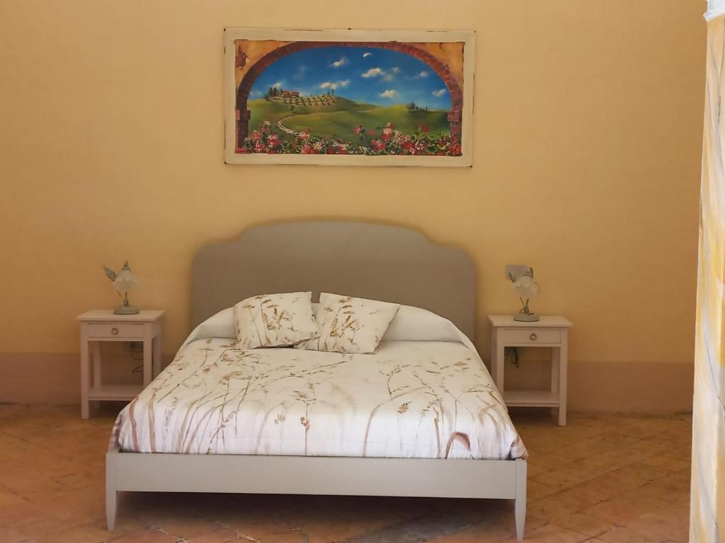 a bedroom with a bed with two tables and a painting at La casetta sull'arco in Sarteano