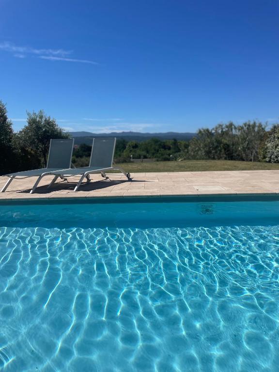 deux chaises assises à côté d'une piscine dans l'établissement Villa avec vue sur le pilon du roi, à Aix-en-Provence
