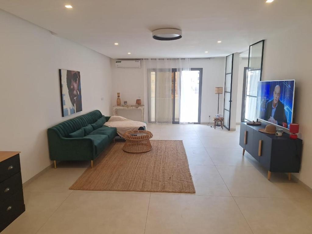 a living room with a green couch and a bed at Furnished studio for rent in city in Dakar