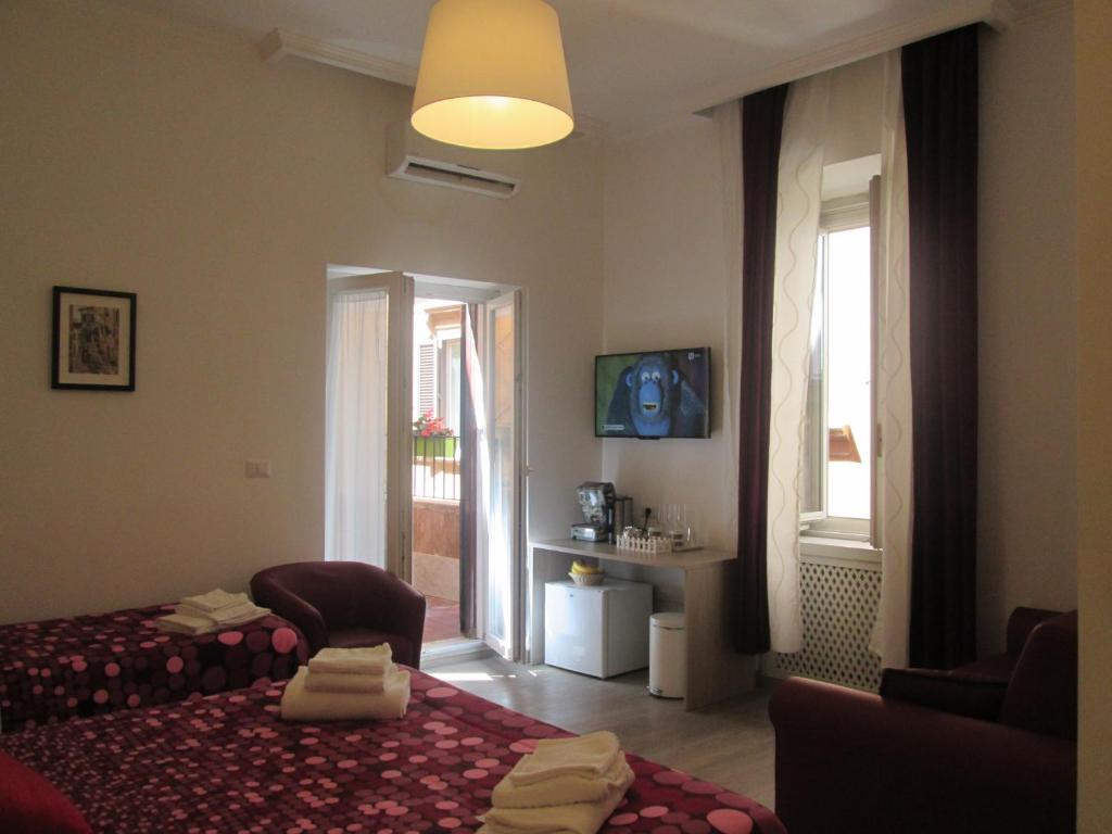 Un dormitorio con una cama y una silla y una ventana. en Trevi Elegance Suite, en Roma
