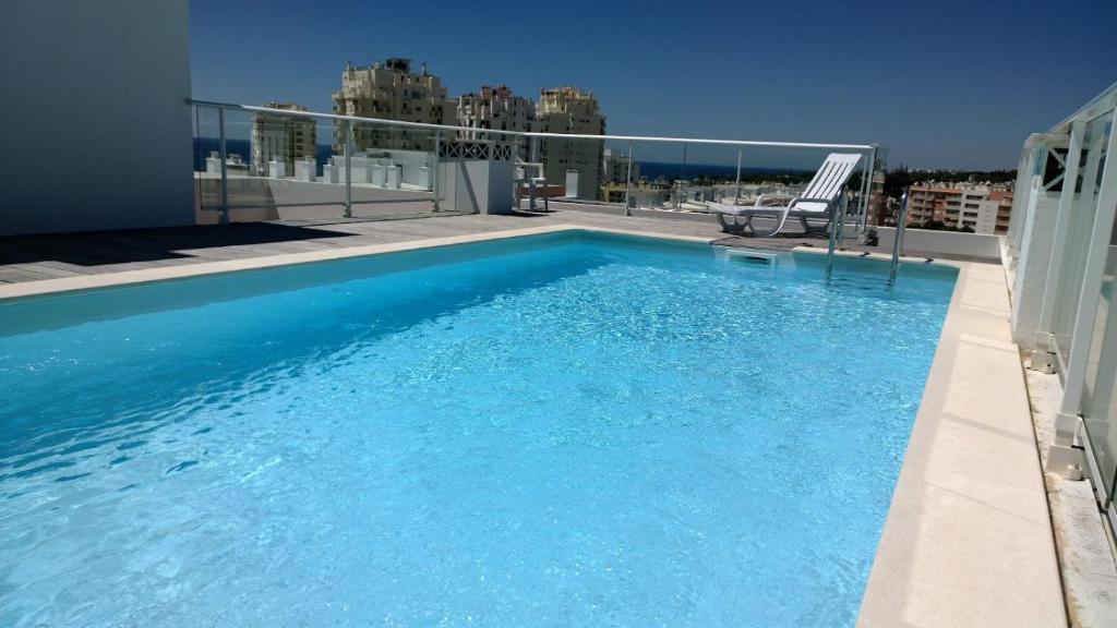 ein großer blauer Swimmingpool auf einem Gebäude in der Unterkunft Nautic Vista Mar - Apartment in Armação de Pêra