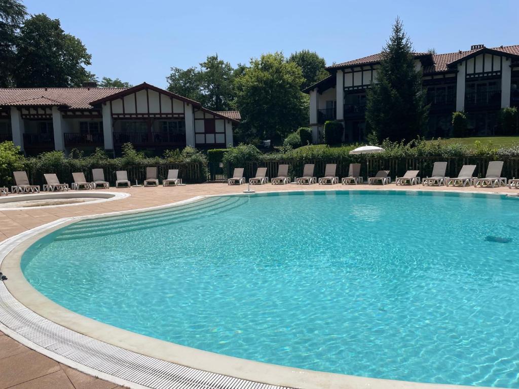 une grande piscine devant un hôtel dans l'établissement Séjour 4 personnes - Pays Basque, à Uhart-Cize