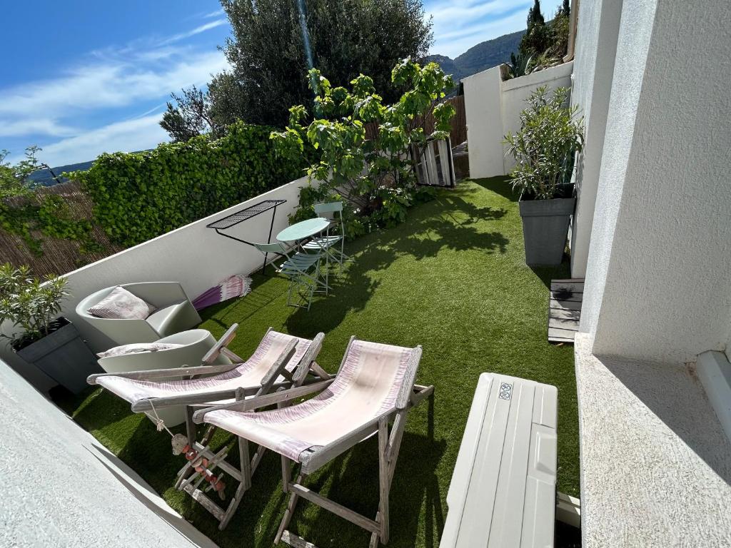 - un balcon avec 2 chaises et une table sur gazon dans l'établissement Studio Calme aux terrasses de Cassis, à Cassis