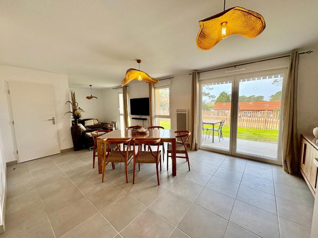 a kitchen and dining room with a table and chairs at Appartement 2 chambres à 600m de l'Océan in Mimizan-Plage