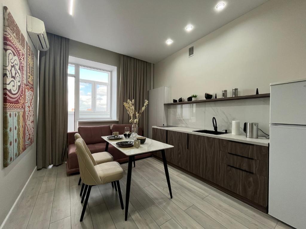 a kitchen and living room with a table and a couch at Арман комфорт in Aktobe