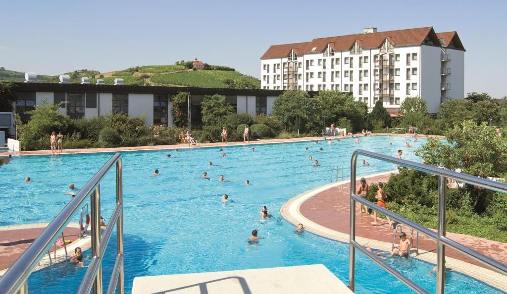 ein großer Pool mit vielen Menschen darin in der Unterkunft Mercure Hotel Bad Duerkheim An Den Salinen in Bad Dürkheim