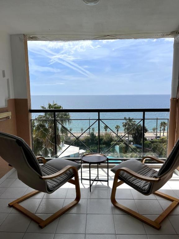 une chambre avec deux chaises et une table et une vue sur l'océan dans l'établissement Cannes cozy 4-person appartement piscine, vue mer exceptionnelle, à Cannes