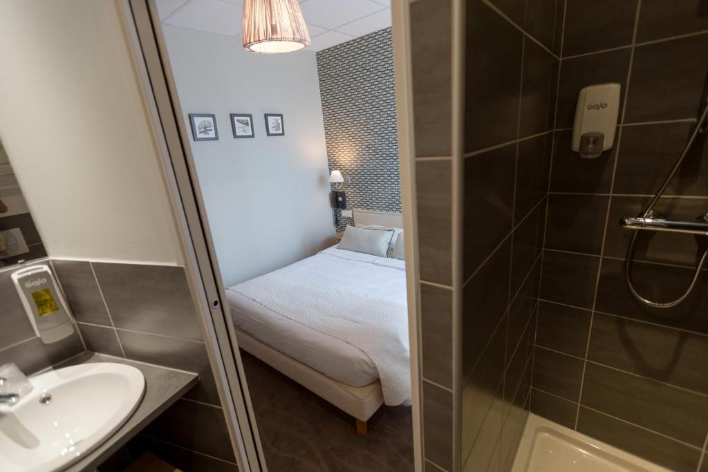 a small bathroom with a bed and a shower at Cit'Hotel Les Alizes in Dinard