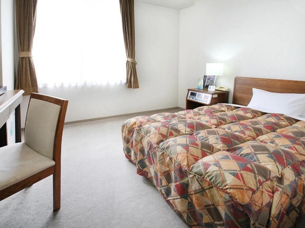 Postel nebo postele na pokoji v ubytování 寝屋川トレンドホテル