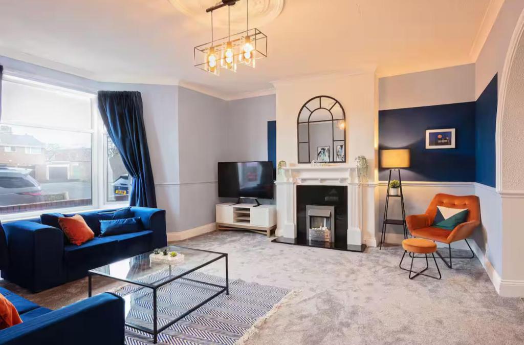 een woonkamer met een bank en een open haard bij Stanley-3 Bdrm House Ideal for Contractors Near Beach in Blythe