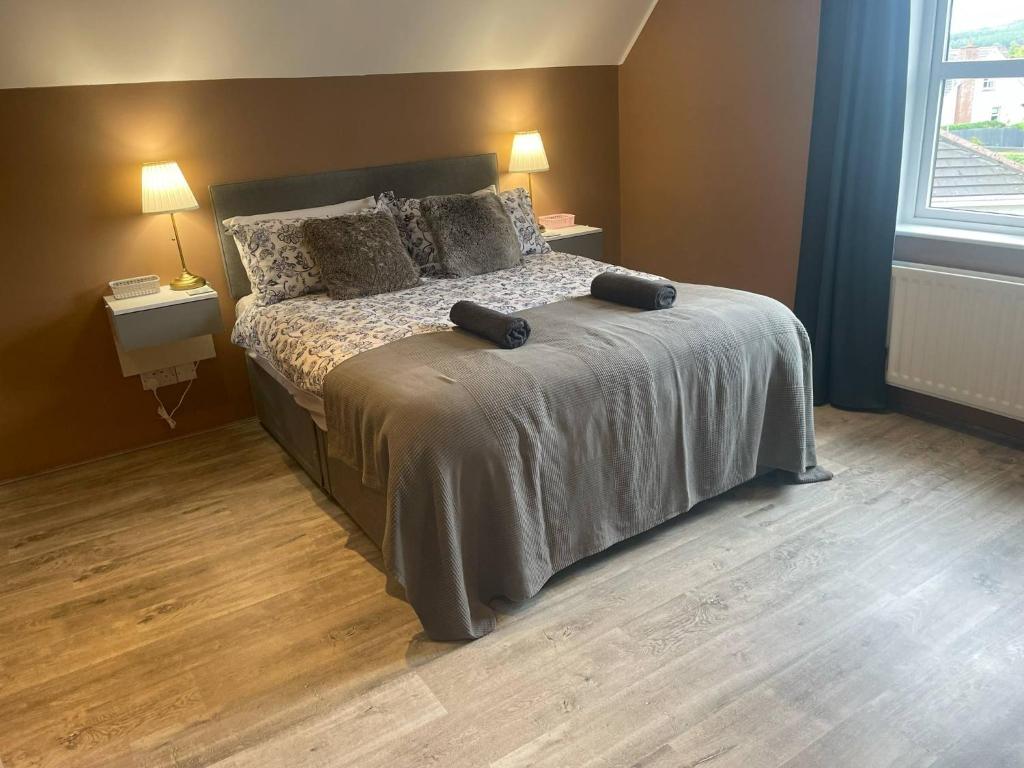 a bedroom with a bed with two pillows on it at Wind Rose Rooms in Ballycastle