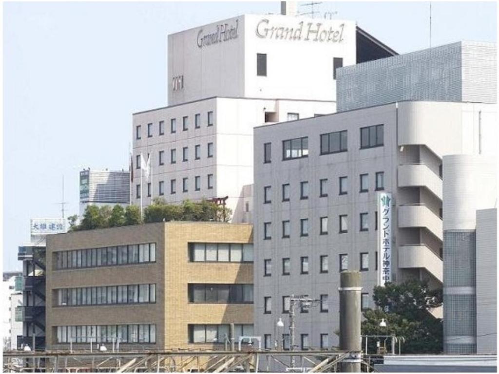 ein hohes weißes Gebäude mit einem großen Hotelschild drauf in der Unterkunft Grand Hotel Kanachu Hiratsuka in Hiratsuka