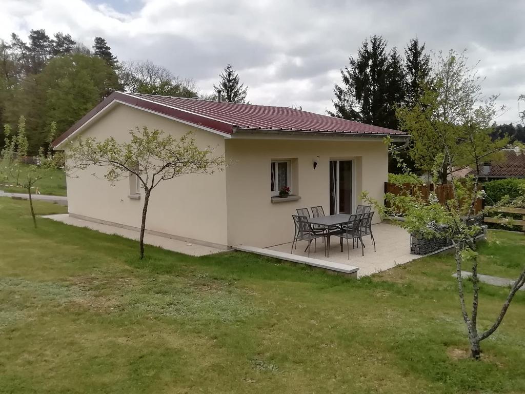 une petite maison blanche avec une table et des chaises dans l'établissement La CHANTERELLE, à Mortagne