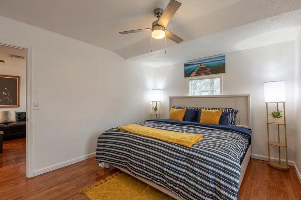 a bedroom with a bed and a ceiling fan at Two Homes - Charming Home and Cozy Bungalow in Tulsa