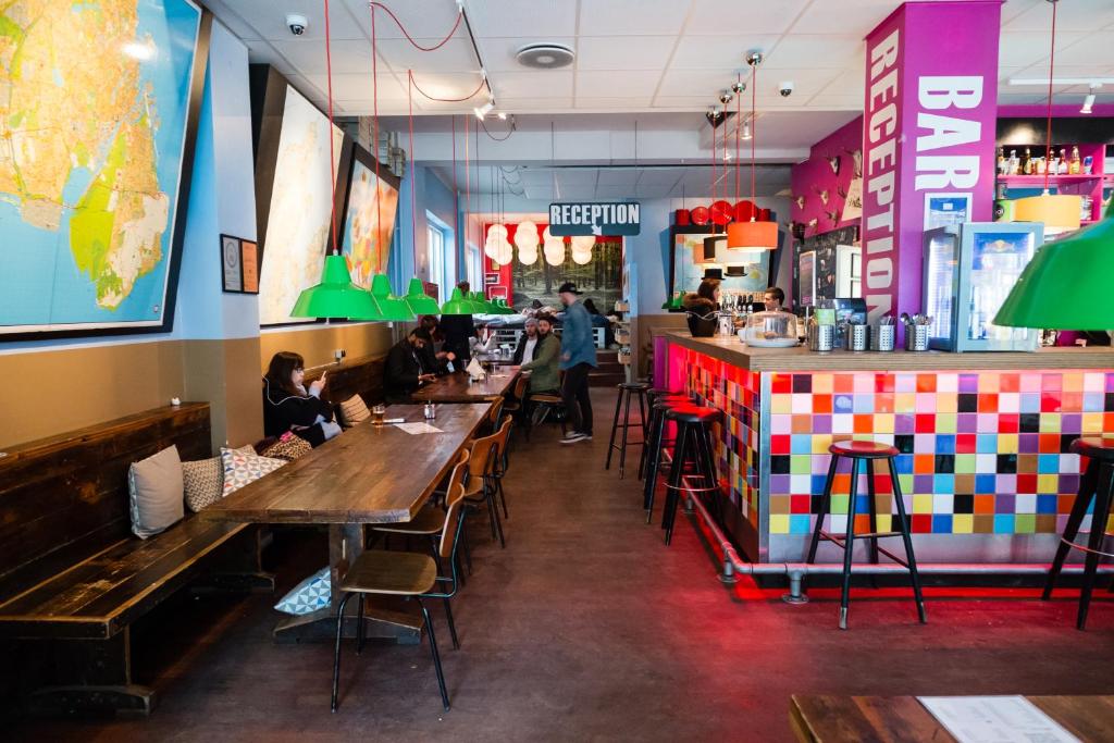 a restaurant with people sitting at tables and a bar at Copenhagen Downtown Hostel in Copenhagen