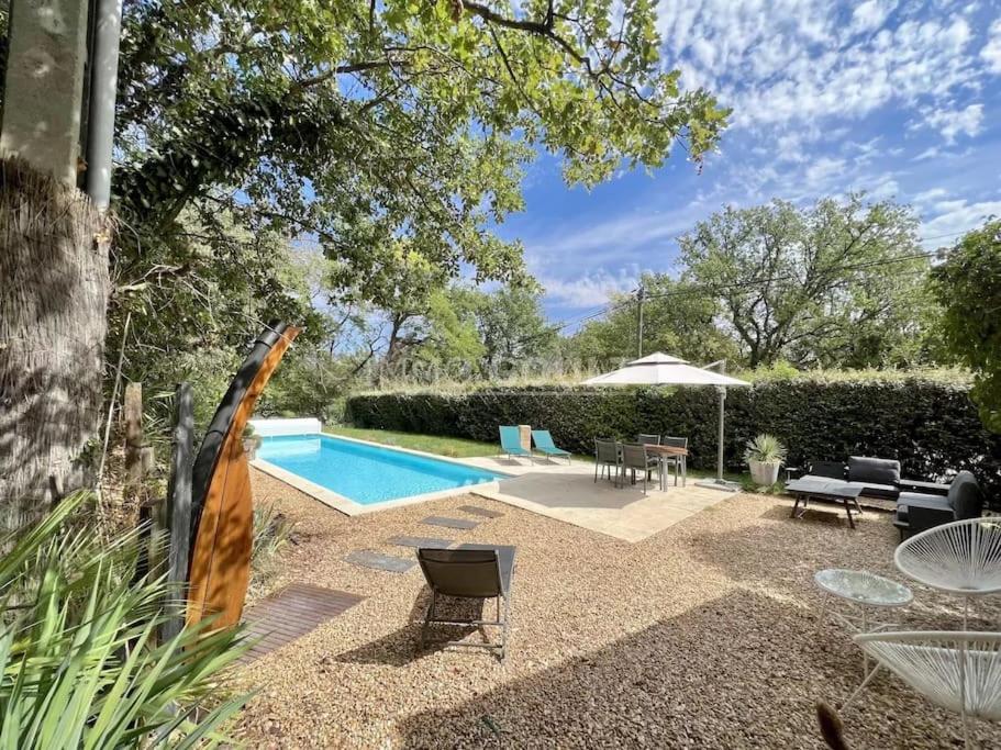 une cour avec une piscine et un parasol dans l'établissement Villa climatisée avec piscine, à Gordes