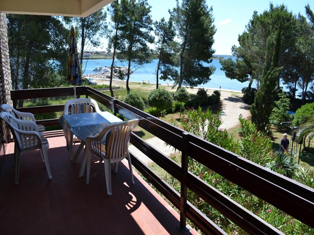 a balcony with a table and chairs and a view of the beach at Apartments Sun Gardens in Privlaka
