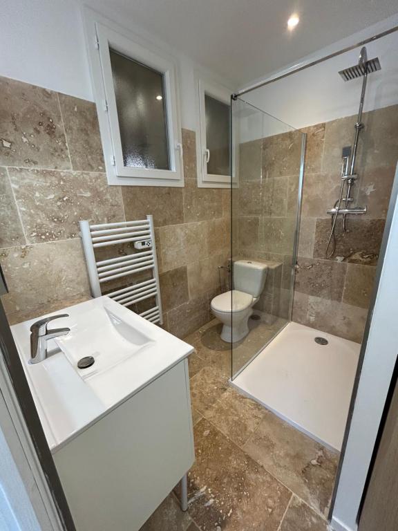une salle de bain avec un lavabo, une douche et des toilettes dans l'établissement Le Brasilia, à Six-Fours-les-Plages