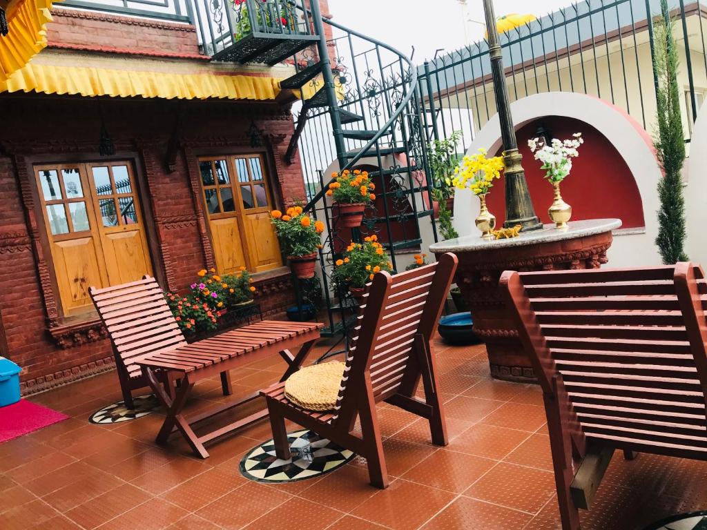 un patio con due sedie e una scala con fiori di Blue Mountain Home Stay a Kathmandu