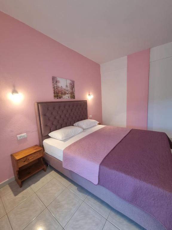 a bedroom with a large bed with a purple blanket at Sun Ray Sivota 7 in Syvota
