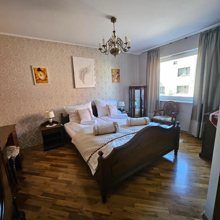 a bedroom with a large bed with a chandelier at Apartament Brownie-Gdynia Orłowo in Gdynia