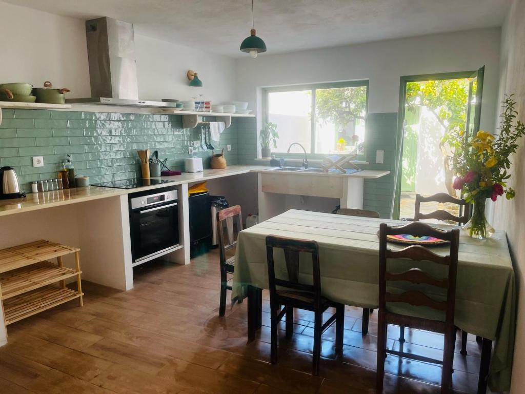 a kitchen with a table and some chairs and a table and a kitchen with at Alojamento DOZE - Aldeia do Telheiro in Monsaraz