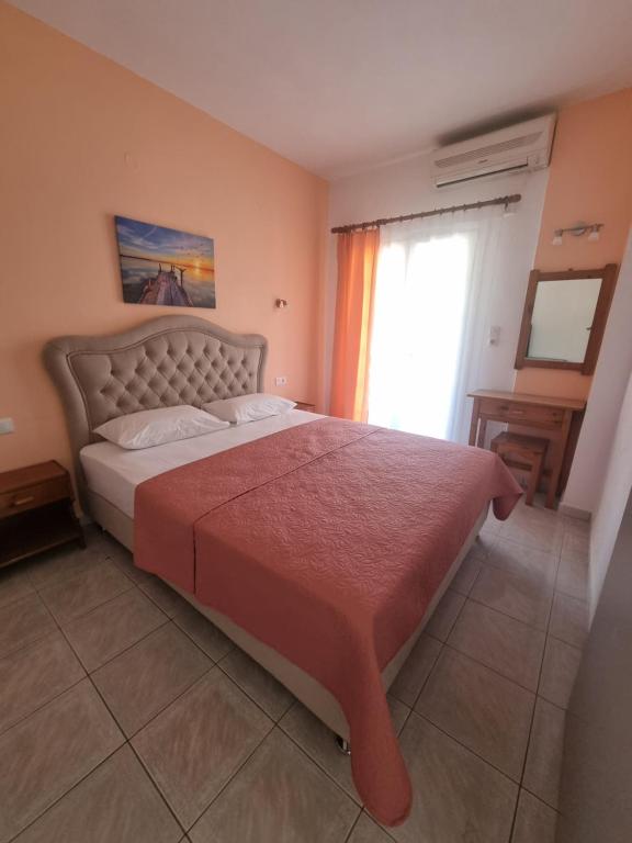 a bedroom with a large bed with a red blanket at Sun Ray Sivota 8 in Syvota