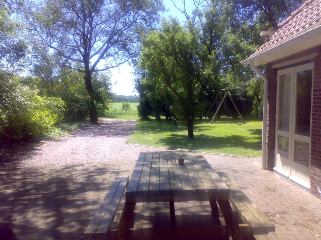 Meppen的住宿－瑞克伯阿歐度假屋，一张野餐桌,坐在带游乐场的房子外