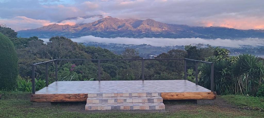 a bench on a hill with a view of a mountain at Coffee Garden Ranch Costa Rica in Concepción