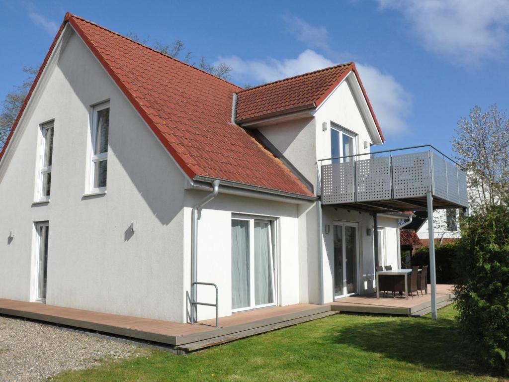 a white house with a red roof at Ferienwohnungen im Veenhuus - Tierfreundlich in Kellenhusen