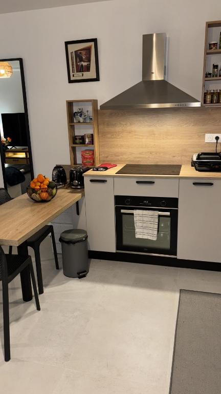 - une cuisine avec une cuisinière et une table avec un bol de fruits dans l'établissement Île Rousse - Vue mer, à La Celle-sous-Gouzon