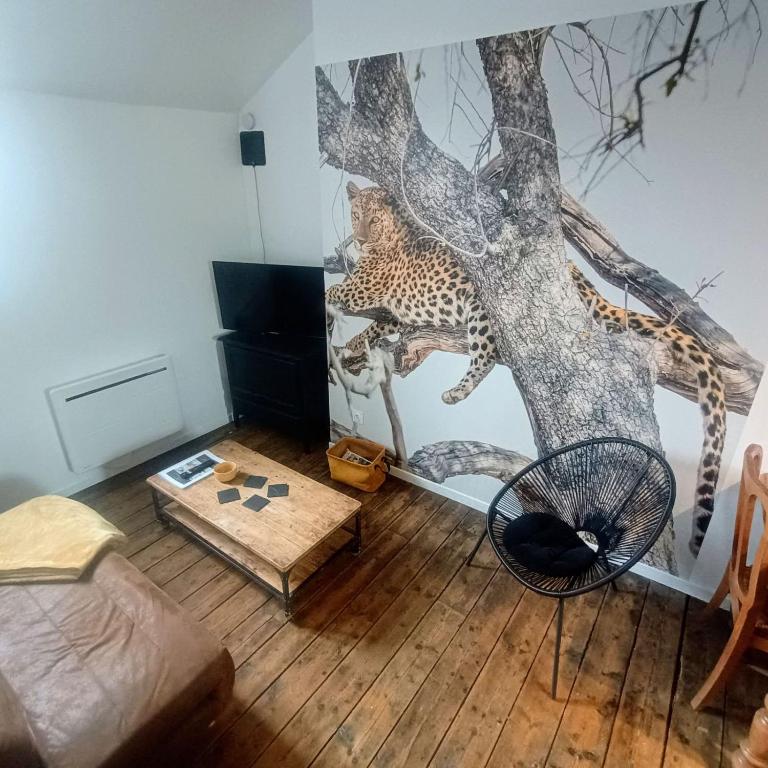 un salon avec une fresque de léopard sur le mur dans l'établissement Terre Sauvage Baie de Somme, à Abbeville