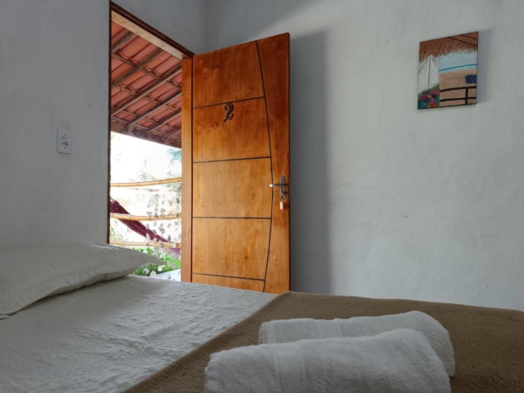 una camera da letto con un letto e una porta di legno di Oásis a Beberibe