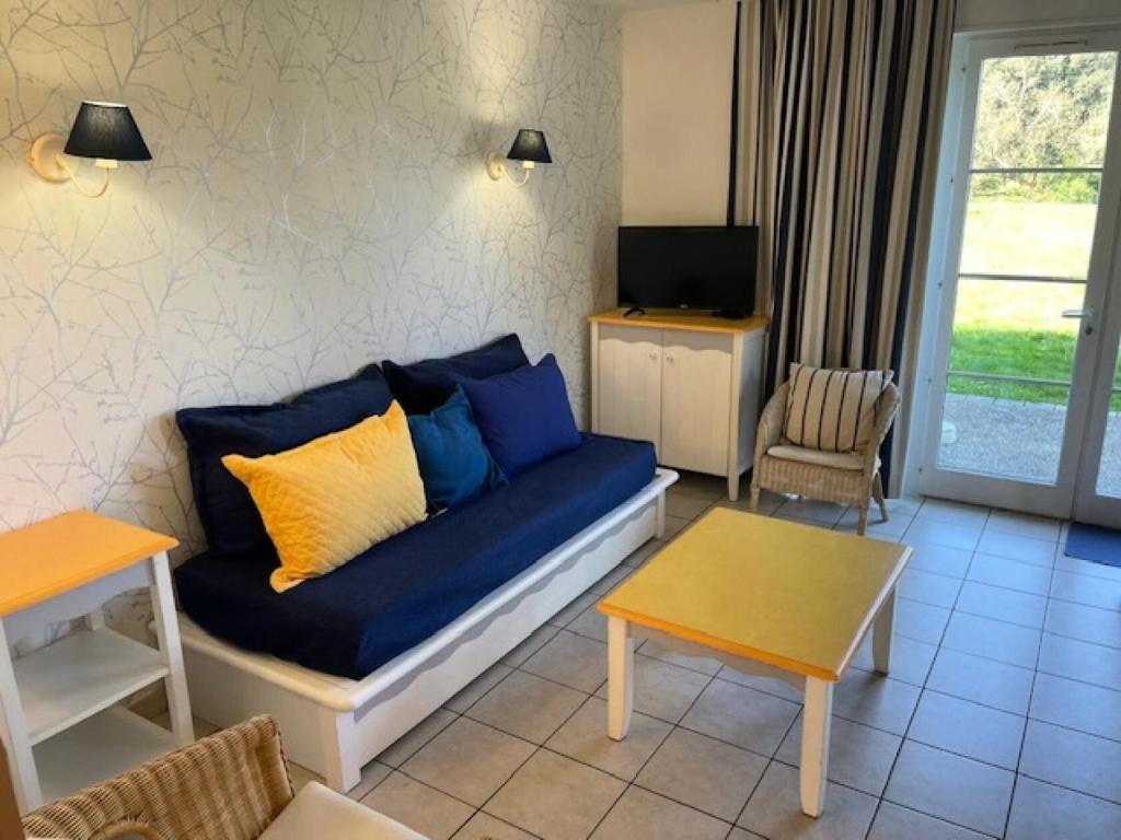 un salon avec un canapé bleu et une télévision dans l'établissement Les Maisons de Port Bourgenay - maeva Home - Maison 3 pièces 8 pers Sélection MAE-5843, à Talmont-Saint-Hilaire