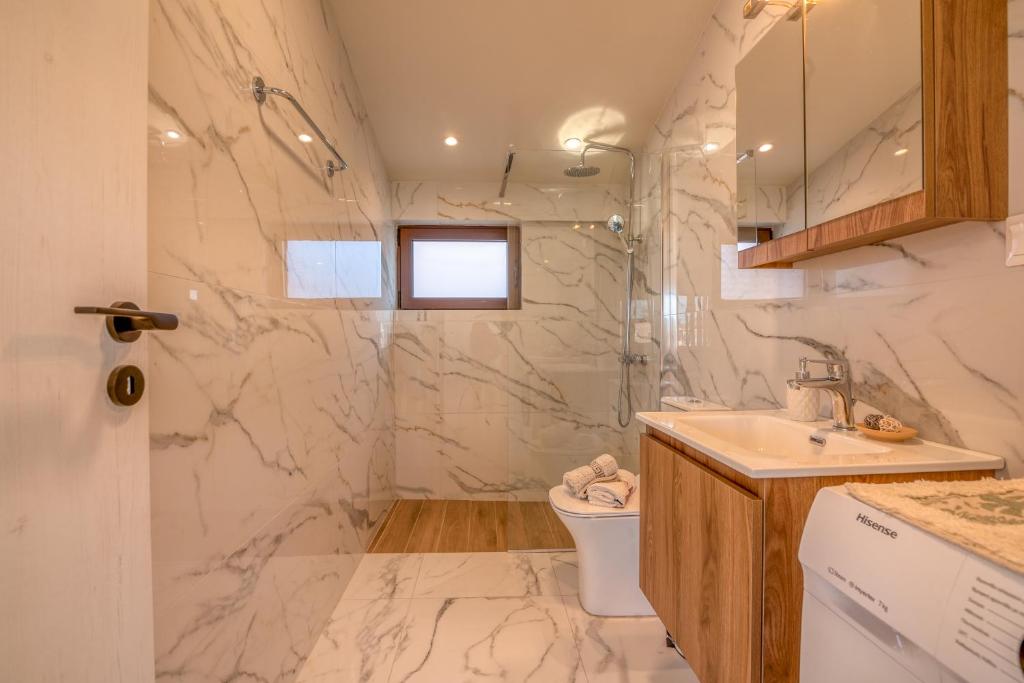 a white bathroom with a sink and a toilet at Angela Home, 5Street, Perivolia in Perivólia