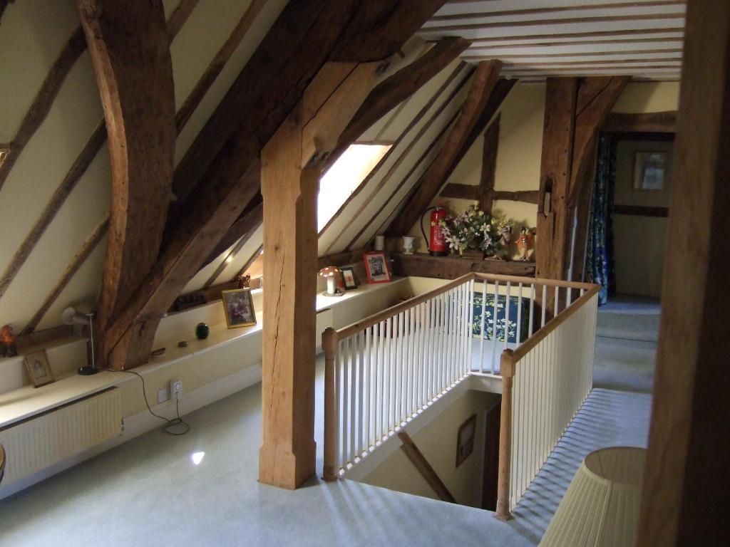 eine Treppe im Dachgeschoss mit Holzbalken in der Unterkunft Westcourt Farm in Shalbourne