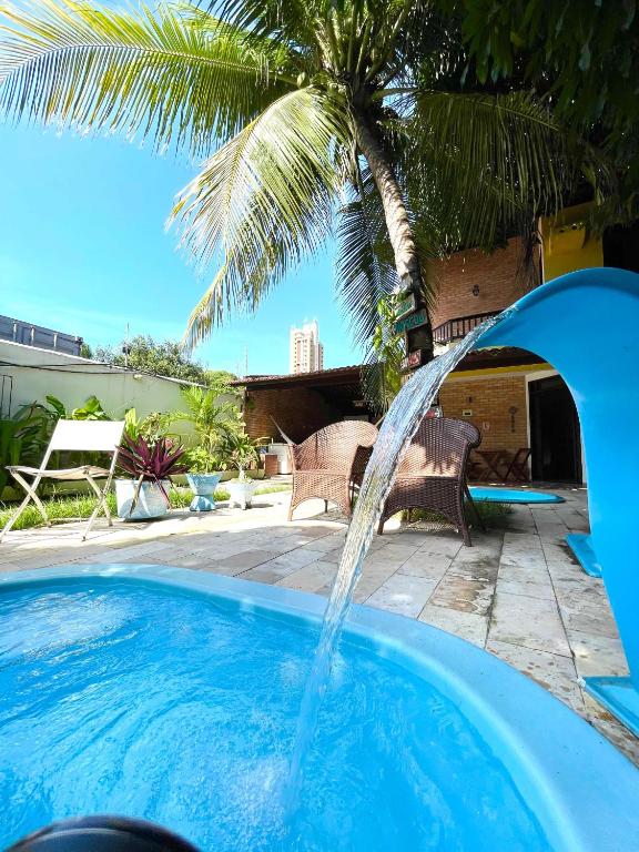 ein Schwimmbecken mit einem Springbrunnen in der Unterkunft Pousada Flor D' Açucena in Natal
