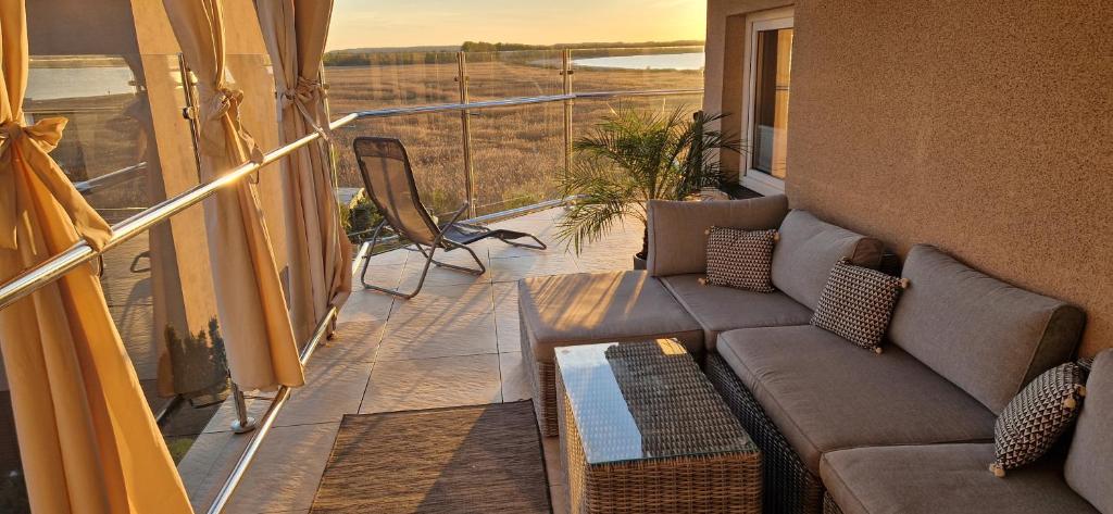 a balcony with a couch and a table at Willa Dobryłko in Rewa
