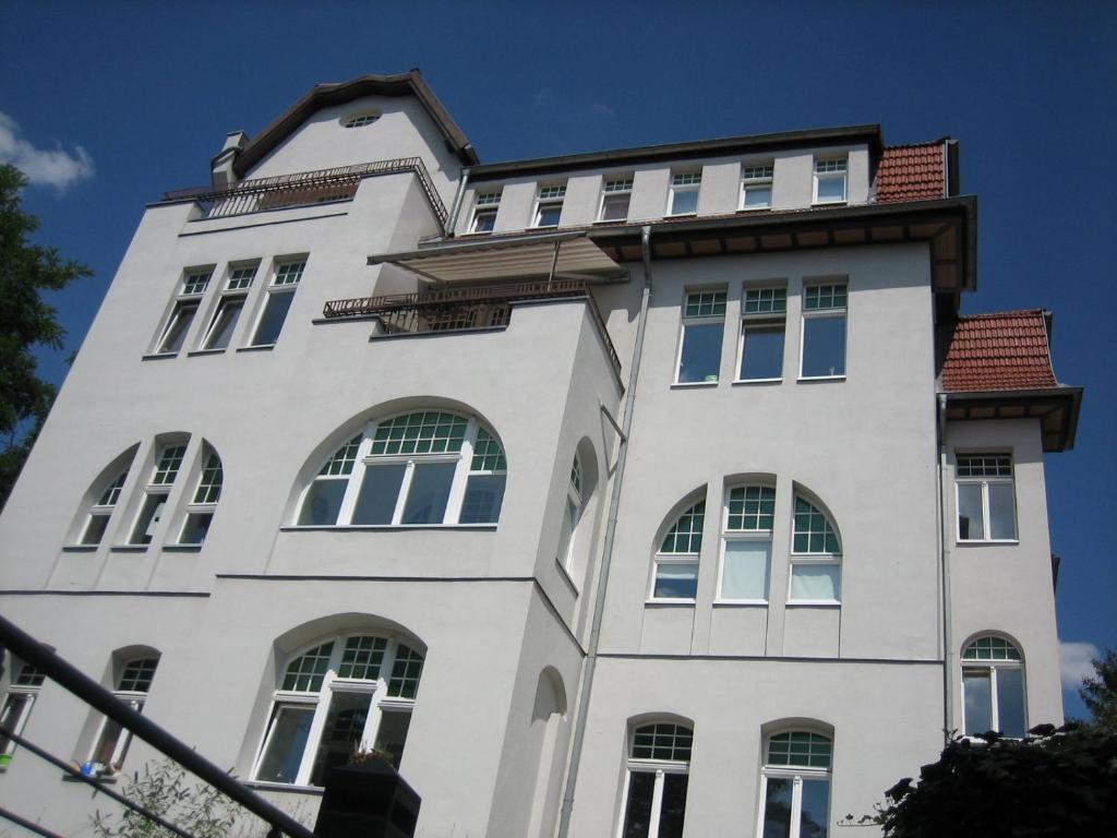 ein weißes Gebäude mit Fenstern und einem Dach in der Unterkunft Wölfele Apartment in Quedlinburg