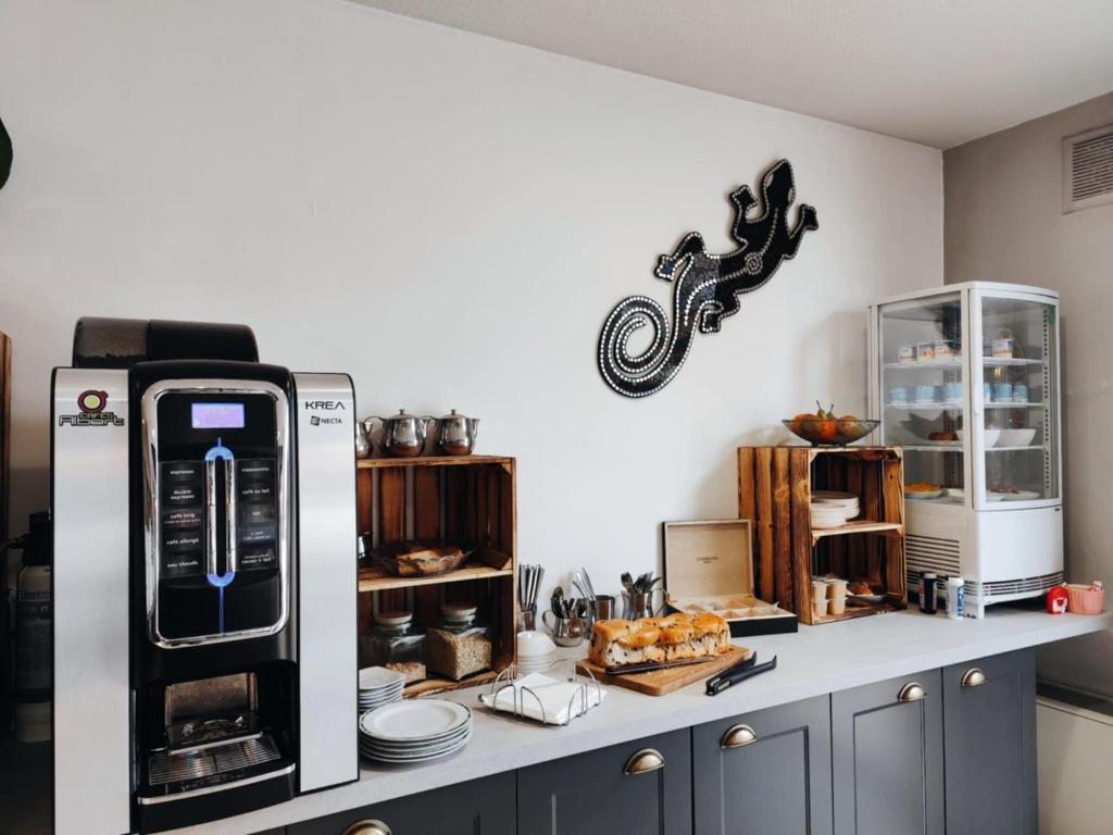 a kitchen with a counter with a refrigerator and other appliances at Hôtel Saint Jacques in Parthenay